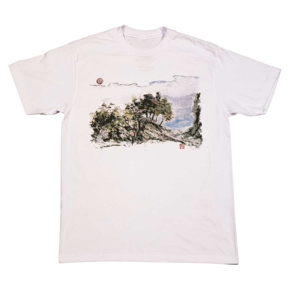 The Hillside Southside White Tee by Nguyen Duc Hien features a classic fit, soft USA cotton, and a watercolor-style landscape with trees, hills, clouds, and East Asian-inspired red stamps. Tear-away label adds extra comfort.