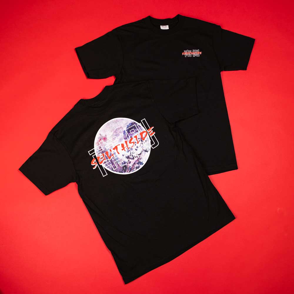 Two Kanji Southside Black Tees by Nguyen Duc Hien, both short-sleeved and 100% cotton, laid on a red surface; one has an oversized astronaut streetwear graphic with "SALT LYS," the other features a small chest logo.