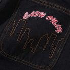 A close-up of Logo Baggy Denim Jeans Washed Black Cash Only pocket shows orange stitching, an embroidered city skyline, and "CASH ONLY" in red and white—ideal for baggy denim fans.