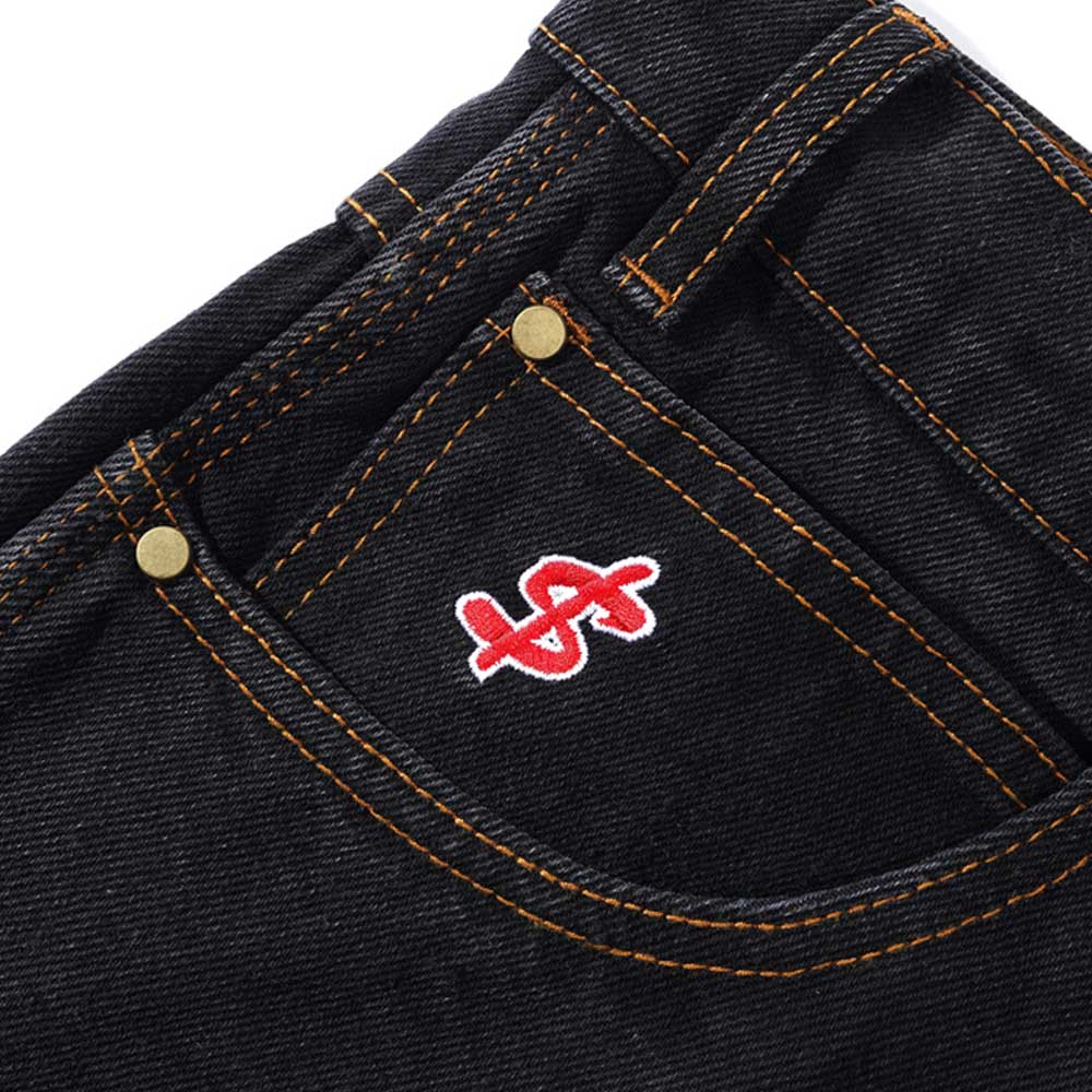 Close-up of the Logo Baggy Denim Jeans Washed Black Cash Only, showing an oversized pocket with orange stitching, brass rivets, and a bold red and white embroidered dollar sign for a standout cash only look.