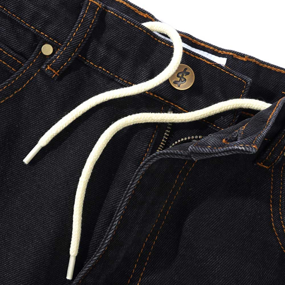 Close-up of Logo Baggy Denim Jeans Washed Black Cash Only, featuring orange stitching, a brass waist button, and a white drawstring at the waistband. The fly is partially open.