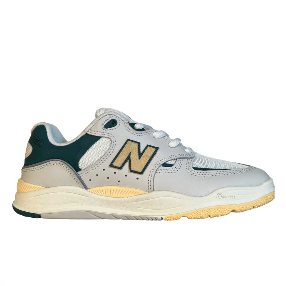The 1010 AL New Balance Numeric Suede Shoes in white, green, and yellow feature gray and off-white tones, dark green accents, mesh panels, a yellowish sole, and a bold N logo on the side—perfect for both athletic style and skateboarding.
