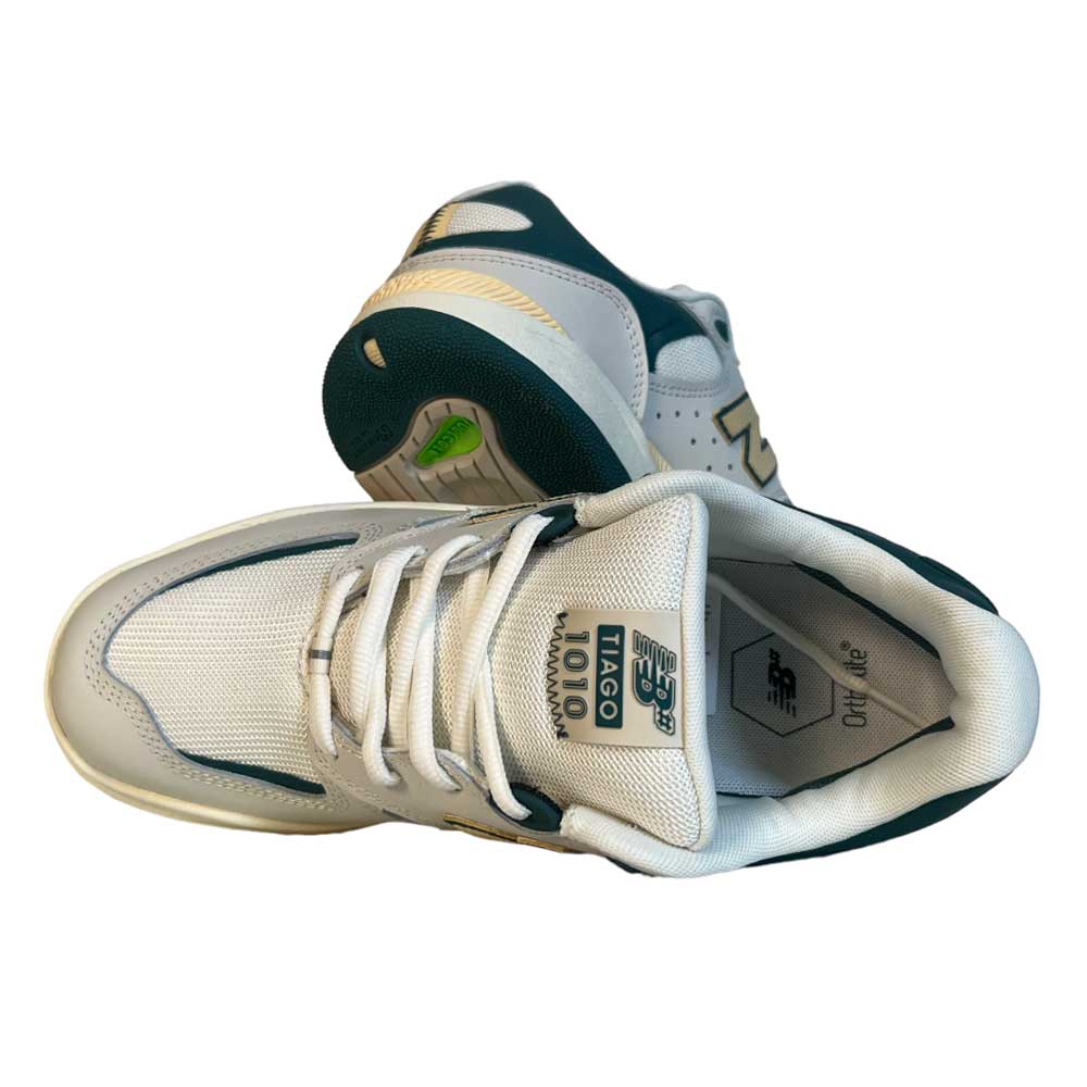 A pair of 1010 AL New Balance Numeric Suede Shoes in white, green, and yellow—one upright, one on its side—highlighting the mesh upper, logo, and sole details; ideal for fans of Tiago Lemos.