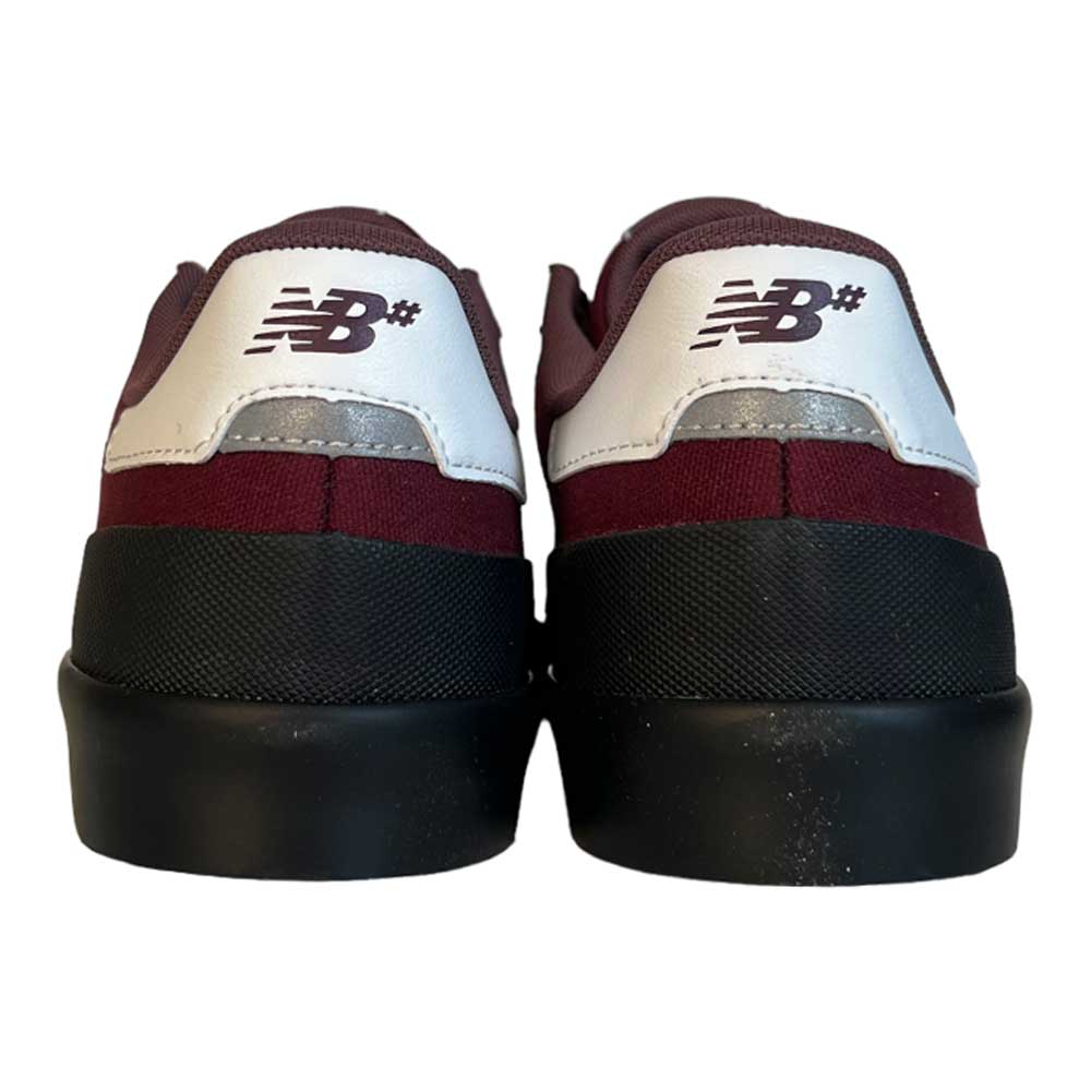 A pair of 272 BNB New Balance Numeric suede shoes in maroon and white, viewed from the back with the NB logo on the heel, featuring a black vulcanized sole and a clean, modern look.