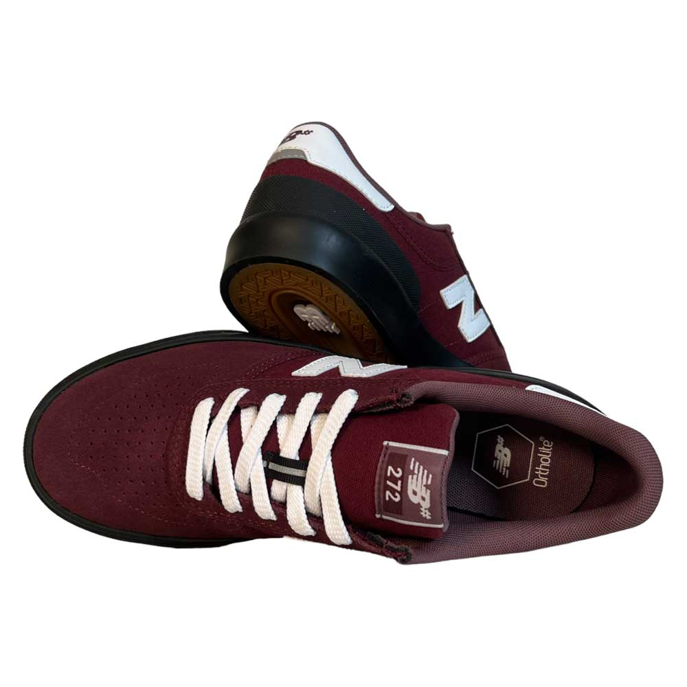 A pair of 272 BNB New Balance Numeric Suede Shoes in maroon, featuring white laces and details—one upright, one on its side revealing the gum vulcanized sole and logo.