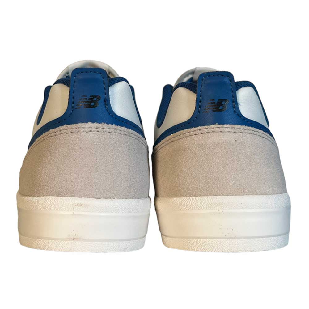 A pair of 306 TWC Jamie Foy New Balance Numeric suede shoes in white, blue, black, and brown are shown from the back, highlighting the logo on the heel tabs. These sneakers blend style, comfort, and durability.