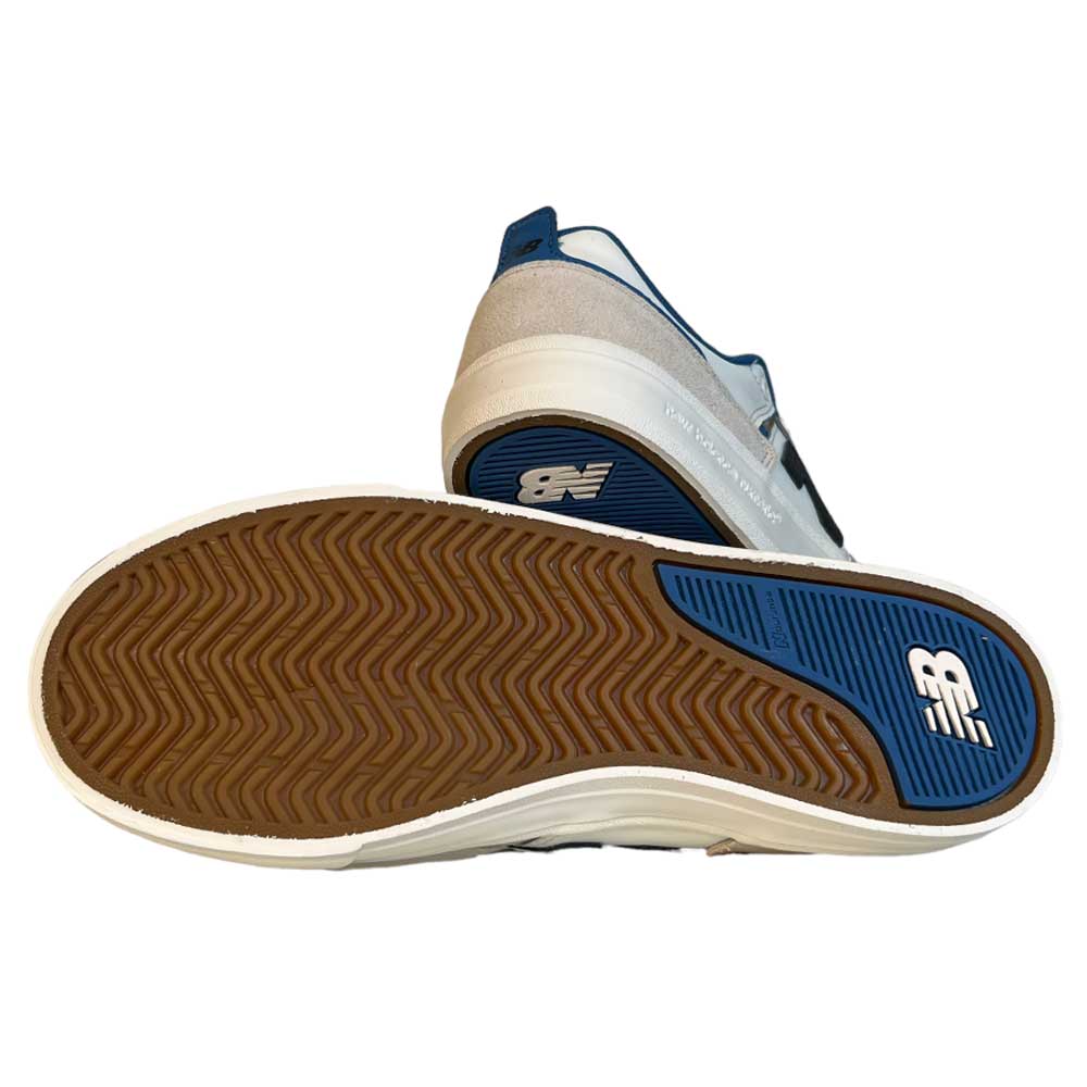 A pair of 306 TWC Jamie Foy New Balance Numeric Suede Shoes in white, blue, black, and brown—one displaying the brown, textured sole with the logo, the other upright to showcase its classic Jamie Foy-inspired suede style.