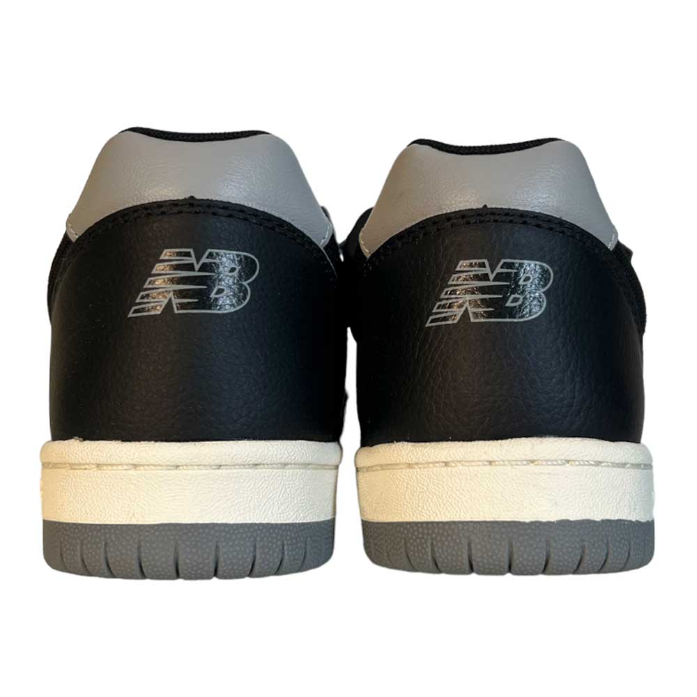 Back view of a pair of black and gray 6600 BBW Tom Knox New Balance Numeric Suede Shoes, featuring white midsoles, gray outsoles, and the NB logo on each heel.