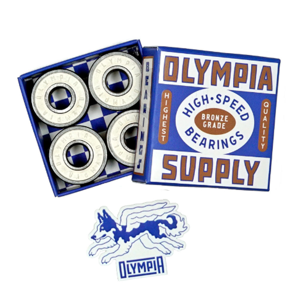 A box labeled Bronze Olympia High Speed Bearings Olympia Supply with four steel ball bearings inside sits next to a blue and white sticker featuring a winged wolf and the word "Olympia.