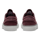 A pair of Janoski GS YOUTH Burgundy Crush Black Suede Nike SB Skateboarding Shoes, viewed from the back, with white soles and black Nike Swoosh logos on the sides.