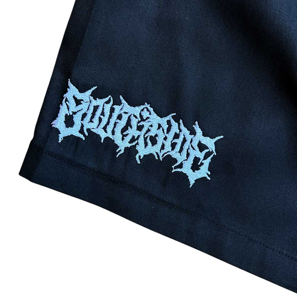 A close-up of black fabric with stylized, jagged white text embroidered in a gothic font reading CULTSIRUS at the corner—featured on Texas Icon Black Southside 94 Shorts.