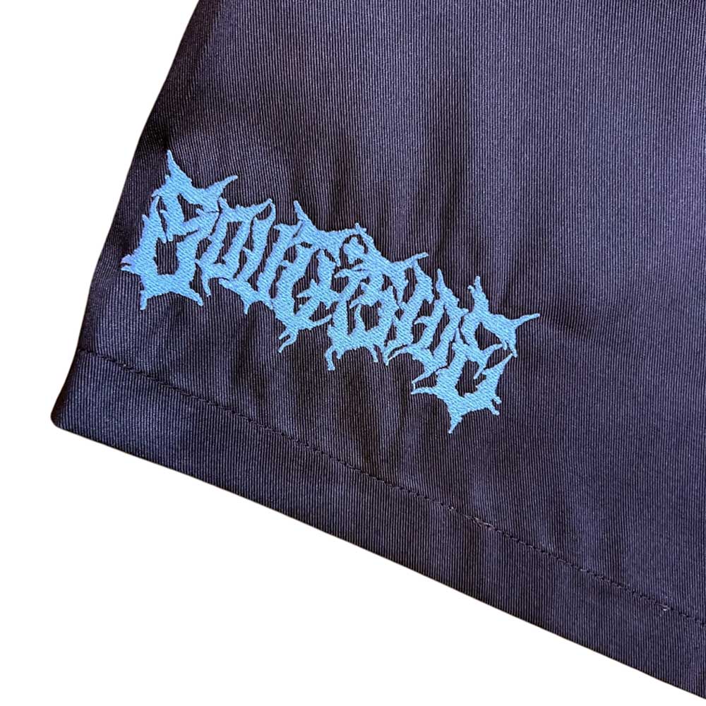 A close-up of black fabric featuring a blue jagged logo near the hem, like the Texas Icon Brown Southside 94 Shorts—perfect for vert ramp skateboarding. The decorative text is hard to read.