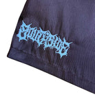 A close-up of black fabric featuring a blue jagged logo near the hem, like the Texas Icon Brown Southside 94 Shorts—perfect for vert ramp skateboarding. The decorative text is hard to read.