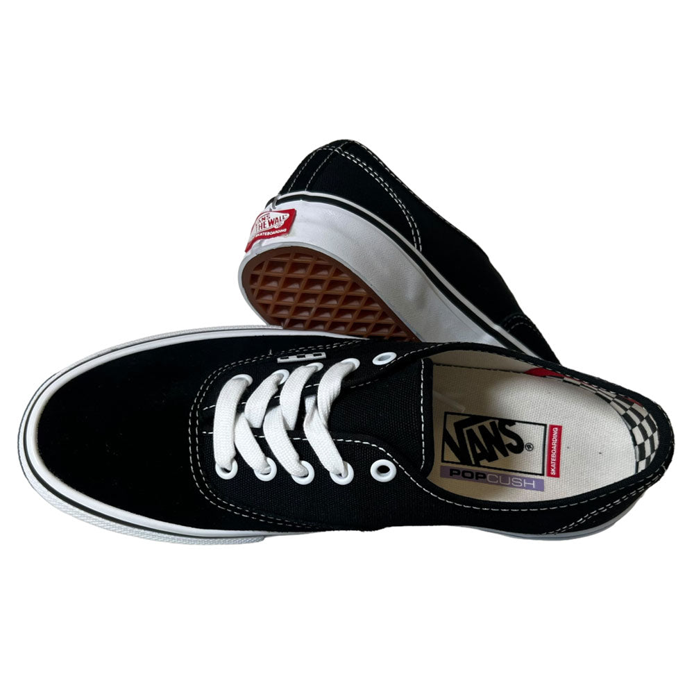 A pair of VNOA5FC8Y28 Suede Canvas Black White Authentic Vans Skateboarding Shoes—one flat, showing the top with white laces and soles, the other propped to display the waffle-patterned brown sole and red Vans logo on the heel.