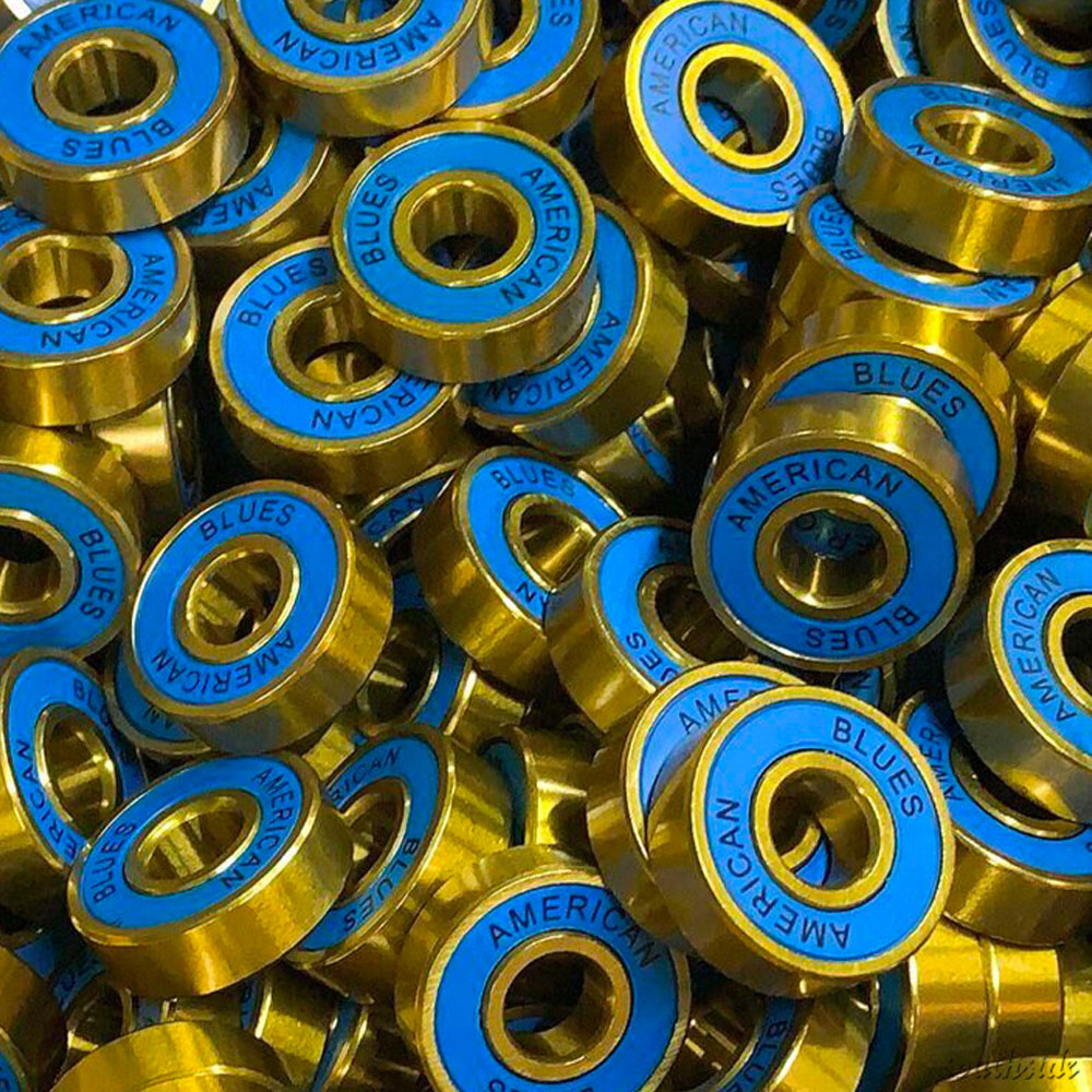 A pile of metallic gold, titanium-coated American Blues Bearings ABEC 9, each with blue centers and "AMERICAN BLUES" printed in a circular pattern around the inner ring.