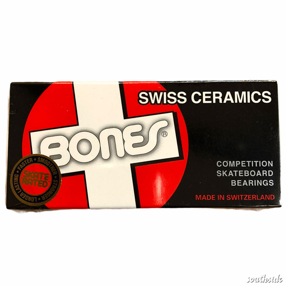 A black and red box labeled “Bones Swiss Ceramic Skateboard Bearings” with a white cross background. The text highlights premium ceramic balls made in Switzerland. A red and black seal is visible on the left side of the packaging.