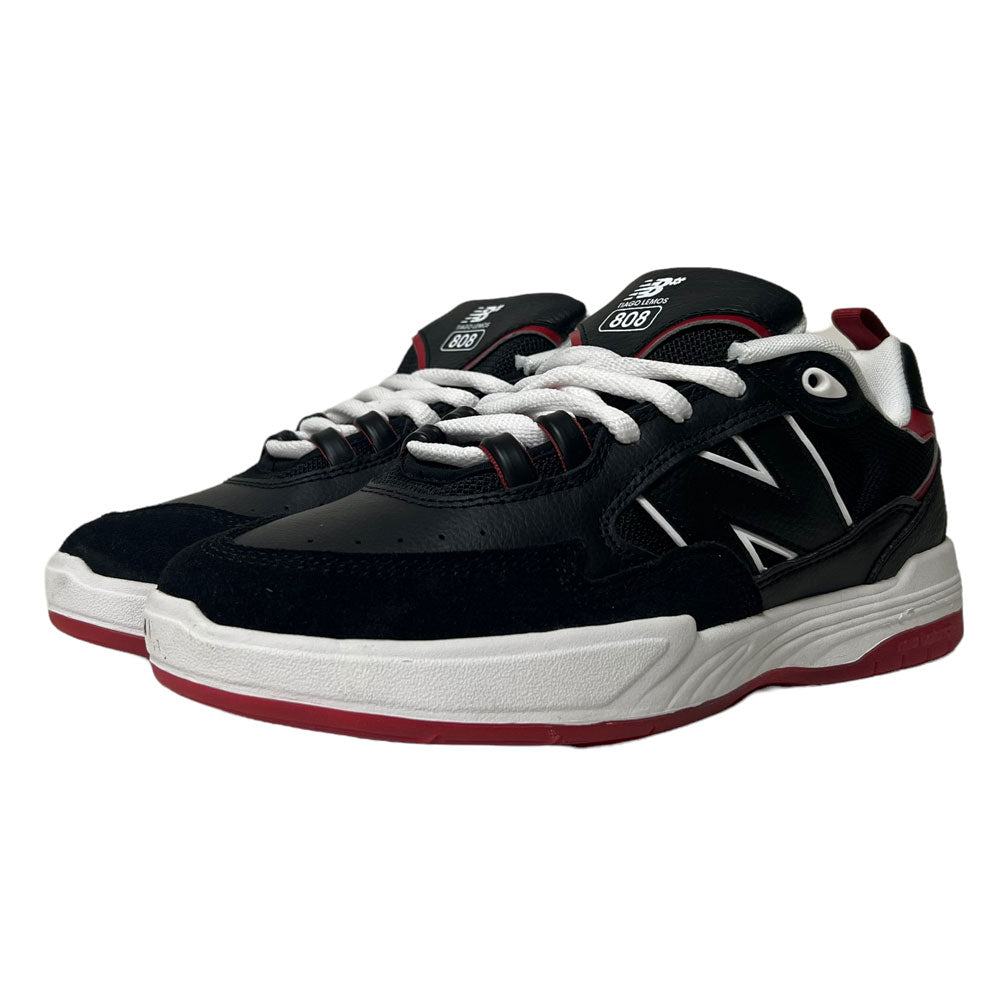 The New Balance NM 808 Tiago Black Red White sneakers feature bold N logos, white laces and midsoles, and red accents, all showcased stylishly against a clean white background.