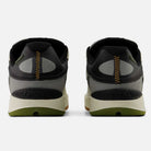 A pair of 1010 B Tiago Lemos Sea Slate Dark Olivine New Balance Numeric Suede Skateboarding Shoes is shown from the back, featuring black, gray, and olive green suede with yellow zigzag stitching and mesh accents on the heels.