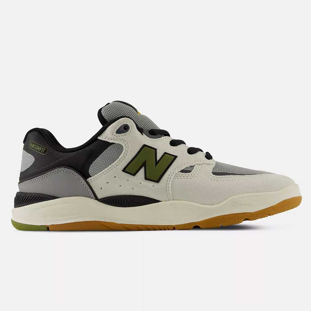 The 1010 B Tiago Lemos Sea Slate Dark Olivine New Balance Numeric Suede Skateboarding Shoes feature a beige and gray upper with black and green accents, an olive green "N" logo, black laces, and a gum rubber sole. Shown from the side on a plain white background, these skate shoes seamlessly combine style and performance for serious skaters.