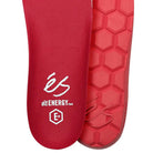 Close-up of two red insoles from the Accel Gray White Suede Es Shoes Skateboarding—one features the éS logo and STI Energy Foam E+ text, while the other showcases a hexagonal tread pattern for skateboarding.