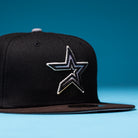 The Magician Houston Astros New Era Hat 5950 Fitted is a black snapback featuring a silver and white outlined star logo inspired by the Houston Astros on the front, displayed on a blue surface with a blue background—perfect for Whatafitted collectors.