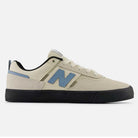 The 306 SBB Jamie Foy Sea Salt Still Water New Balance Numeric suede skateboarding shoes feature a beige upper, black sole, light blue N logo and heel detail, and white laces—a stylish vulcanized sneaker inspired by Jamie Foy.