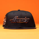 A BLVCK STAR Houston Astros New Era 59FIFTY Fitted Hat in black, featuring the team name embroidered in orange and white on the front, displayed against a solid orange background.