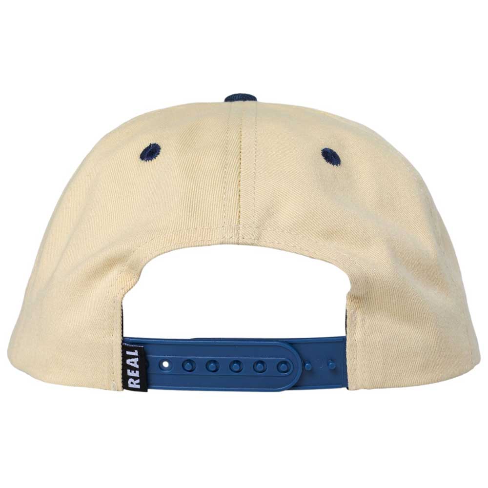 Back view of the 3rd and Army Natural Navy Real Skateboards Hat Adjustable, featuring a beige design with a blue adjustable snap closure and two dark eyelets on top. A small tag with "REAL" is attached near the closure, reflecting its authentic style inspired by 3rd and Army.