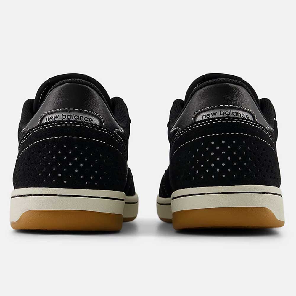 Back view of 440 BCO Black White New Balance Numeric suede skateboarding shoes featuring perforated black suede, white stitching, ABZORB midsole for durability, and gum rubber outsole on a plain background.