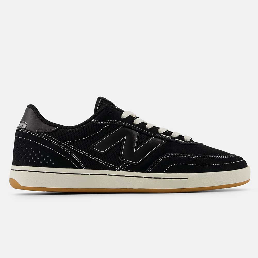 The 440 BCO Black White New Balance Numeric Suede Skateboarding Shoe, featuring white laces, an ABZORB midsole, and a light brown rubber sole, is shown in side profile on a plain white background.