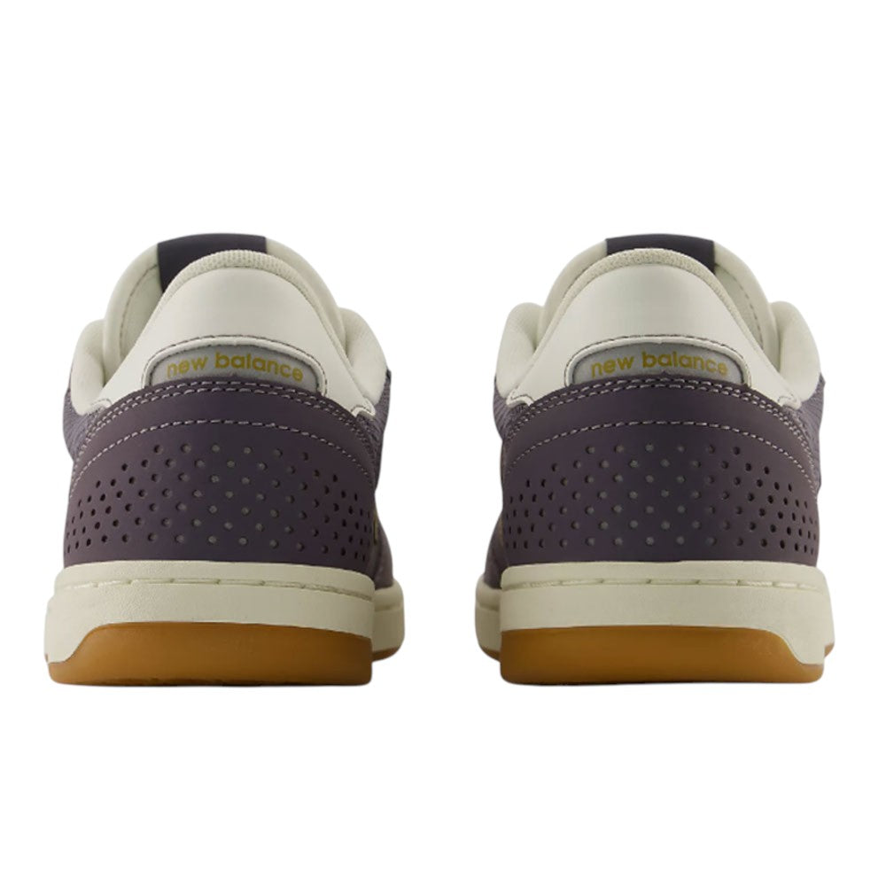 A pair of New Balance Numeric 440 PRB Neptune Gray Seamoss Suede Skateboarding Shoes viewed from the back, featuring perforated purple heels, cream-colored ankle collars, and gum soles. Designed for durability as a skate shoe, this style incorporates an ABZORB midsole for enhanced comfort and impact protection.