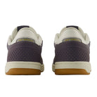 A pair of New Balance Numeric 440 PRB Neptune Gray Seamoss Suede Skateboarding Shoes viewed from the back, featuring perforated purple heels, cream-colored ankle collars, and gum soles. Designed for durability as a skate shoe, this style incorporates an ABZORB midsole for enhanced comfort and impact protection.