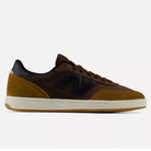 The 440 PRB Pumpernickle Black New Balance Numeric Suede Skateboarding Shoe is shown in a side profile view on a plain background, featuring brown and mustard yellow suede uppers with a black N logo, dark brown laces, perforated heel details, a white sole with ABZORB midsole cushioning, and an NDurance rubber outsole.