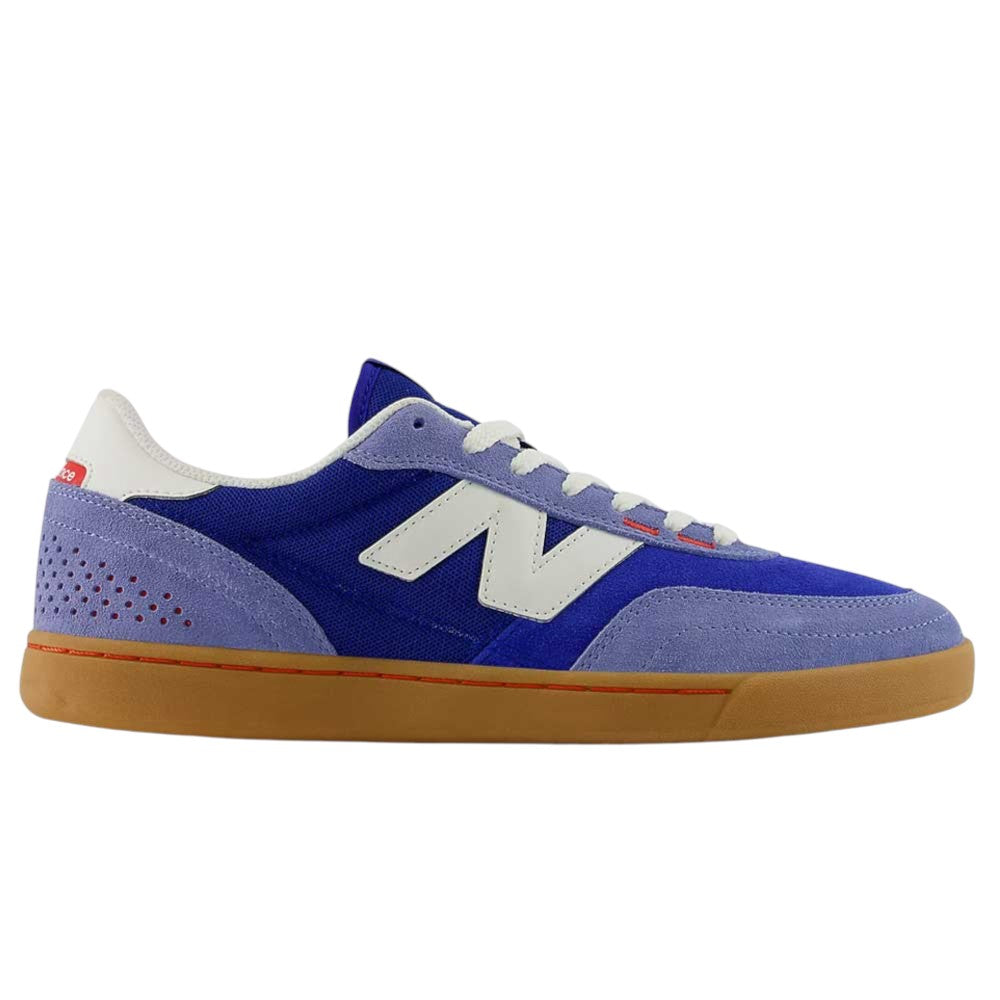Introducing the 440 RTB Blue Gum New Balance Numeric Suede Skateboarding Shoe: This sneaker showcases a blend of blue and purple suede with crisp white laces, a white logo, striking red accents, and a classic gum sole. Displayed in a side profile against a white background, it features a durable construction and an ABZORB midsole for exceptional comfort—perfectly uniting style with high-performance skateboarding needs.