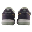 Back view of two 480 NAD New Balance Numeric Suede Skateboarding Shoes in dark purple suede with white midsoles, sage green outsoles, and the brand name embroidered on the heels.