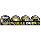 A graphic shows four 56mm Double Duro Black Gum Chubbies OJ Wheels, labeled “DOUBLE DUROS,” with black and gold colors, dice art, and specs: “99A OUTER,” “95A INNER,” “WIDE,” and “56MM.”.