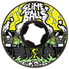 The 58mm Accelerator Vomit Mini Black 99a Slime Balls Wheels skateboard features "Slime Balls" in gooey white letters, green trucks with skulls, black tires, neon green slime, a bold yellow background, and sharp white lightning bolts.