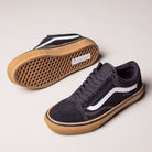 A pair of Vans Skate Old Skool Black Gum White VN000EDNB9K1 suede skate shoes with white side stripes and brown rubber soles—one upright and one showing its textured sole—set against a plain light background.