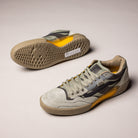 A pair of Vans Skate Ave 2.0 Sage VN000DA1SAG1 Suede Skateboarding Shoes in gray and beige with yellow accents and textured UltimateWaffle soles, displayed on a light surface with one shoe upright and the other sideways to reveal the sole.