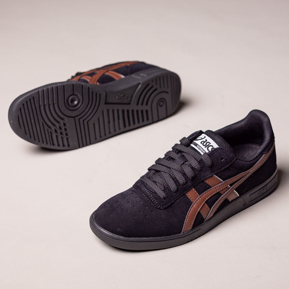 A pair of Gel Vikka Pro Asics Black Reddish Brown 1201A486007 suede skateboarding shoes is displayed on a neutral background; one shoe is upright, and the other reveals its patterned sole.
