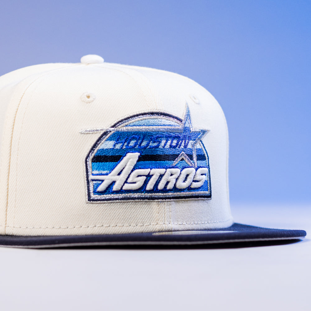 The KB1 Rushmore 35th Chrome Navy Houston Astros New Era Hat 5950 Fitted, in white and navy with blue and silver accents, is shown against a light blue background.