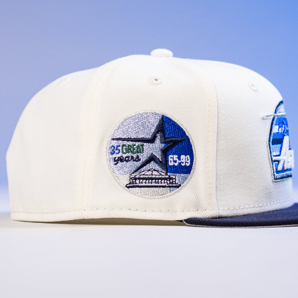 The KB1 Rushmore 35th Chrome Navy Houston Astros New Era 5950 Fitted Hat is white with a blue brim and features a side patch reading "35 Great Years 65-99," highlighted by a star and building design.