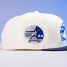 The KB1 Rushmore 35th Chrome Navy Houston Astros New Era 5950 Fitted Hat is white with a blue brim and features a side patch reading "35 Great Years 65-99," highlighted by a star and building design.