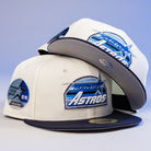 Three KB1 Rushmore 35th Chrome Navy Houston Astros New Era 5950 Fitted hats are stacked on a light blue background. Each features embroidered logos, commemorative patches, a space-inspired design, and flat brims.