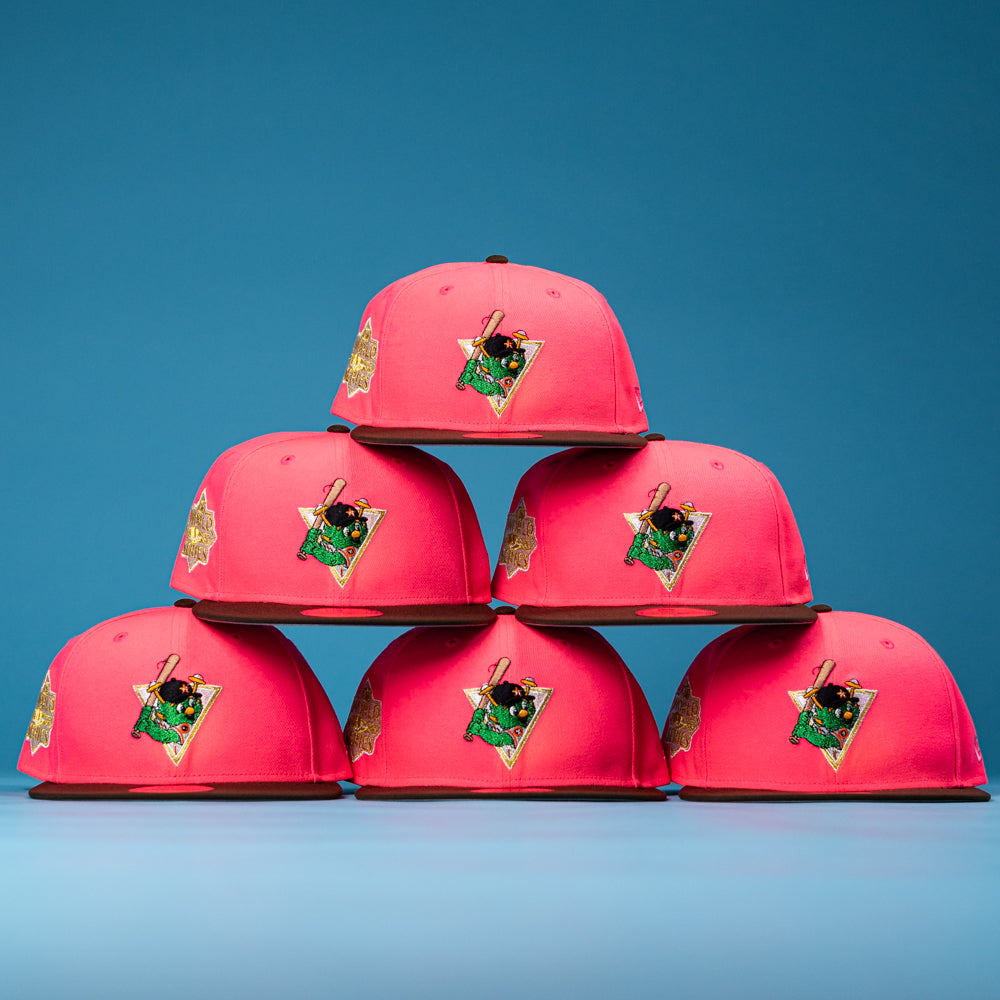 Six Pink Comet WS22 Houston Astros New Era 5950 Fitted hats are stacked in a pyramid against a blue background, each featuring a colorful embroidered front patch with gold and green details.
