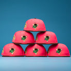 Six Pink Comet WS22 Houston Astros New Era 5950 Fitted hats are stacked in a pyramid against a blue background, each featuring a colorful embroidered front patch with gold and green details.