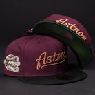 Two 05 Debut Maroon Black Houston Astros New Era Hat 5950 Fitted caps, each with a black brim and gold "Astros" embroidery; one includes a 2005 World Series patch. Both are displayed against a dark background.