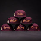 Six 05 Debut Maroon Black Houston Astros New Era Hat 5950 Fitted caps are stacked in a striking pyramid against a dark background, showcasing their elegant gold embroidery.