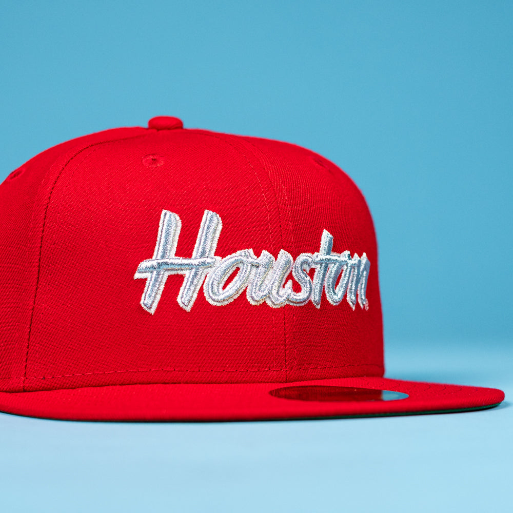 Show your Houston Cougars pride with the Cougar Scarlet 5950 Fitted New Era Hat, featuring "Houston" in white script on bright red, set against a light blue background—perfect for fans.