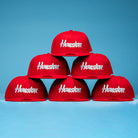 Six Cougar Scarlet 5950 Fitted New Era Hats with "Houston" in white, arranged pyramid-style on a blue backdrop—a striking salute to Houston Cougars pride.